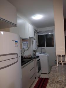 a small kitchen with white cabinets and a refrigerator at Apto 3 QUARTOS NA GLORIA - 102 in Macaé