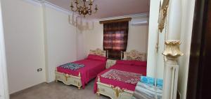 a bedroom with two beds and a chandelier at Charming sunset,Panoramic Nile view & pyramid view in Cairo