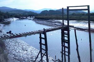 un puente sobre un río junto a un cuerpo de agua en Casa Rural Ozollo en Gautegiz Arteaga