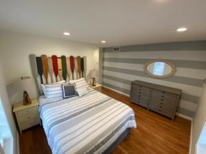 een slaapkamer met een bed met gestreepte muren en een spiegel bij Devil's Lake Inn and Devil's Lake Inn Too in Manitou Beach