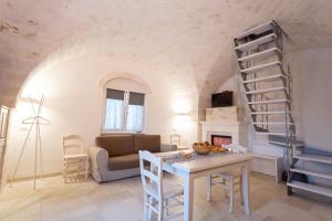 uma sala de estar com uma mesa e uma escada em espiral em Trullo dei maestri em Locorotondo