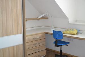 een kamer met een bureau en een blauwe stoel bij apartmán 2+1 in Huštěnovice