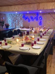 a long table with plates of food and candles at Veccepļi kempings in Spāre +46 photos
