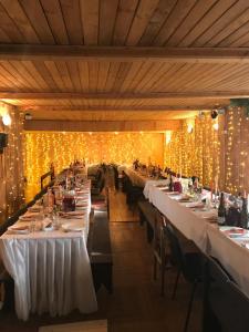 a row of tables in a restaurant with lights at Veccepļi kempings in Spāre