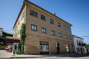 un gran edificio de ladrillo en una calle de la ciudad en Hotel Villa de Ayerbe, en Ayerbe