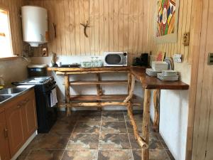 een keuken met een houten tafel en een magnetron bij Doña Marta del Truful in Melipeuco