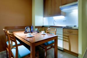 a kitchen with a table and chairs and a refrigerator at Hesperia Sant Joan in Sant Joan Despí