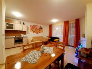 a kitchen and living room with a table and a christmas tree at Апартамент КАРЛИН in Pamporovo
