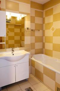La salle de bains est pourvue d'un lavabo et d'une baignoire. dans l'établissement Apartments Biljana - 150m from beach, à Gradac