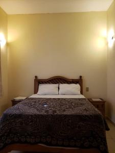 a bed in a room with two nightstands and a bed sidx sidx sidx at Hotel Centro Historico in Puebla
