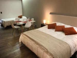 a bedroom with a bed and a table with chairs at Bariloche View Apartment in San Carlos de Bariloche