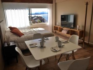 Bariloche View Apartment في سان كارلوس دي باريلوتشي: غرفة مع طاولة وكراسي وسرير