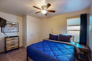 a bedroom with a blue bed and a ceiling fan at Rim Vista 11A2 in Moab