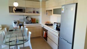 a kitchen with a glass table and a refrigerator at Laguna Bahia Algarrobo in Algarrobo