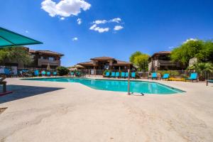 een zwembad in een resort met blauwe stoelen bij Vistoso Resort Casita #136 in Oro Valley