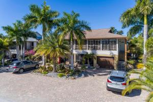 una casa con dos coches estacionados frente a ella en #1 Island Hideaway en Fort Myers Beach