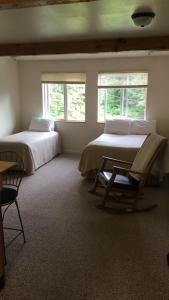 a room with a bed, chair and a window at Exit Glacier Lodge in Seward