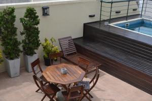a patio with a table and chairs and a swimming pool at Piccaluga Apartments in Buenos Aires