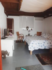 Schlafzimmer mit einem Bett, einem Tisch und Stühlen in der Unterkunft Suite Indiana Ilhabela in Ilhabela
