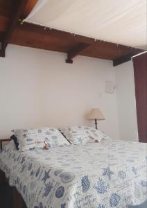 een slaapkamer met een bed met een blauw en wit dekbed bij Suite Indiana Ilhabela in Ilhabela