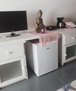 einen Schreibtisch mit einem Monitor und einer Statue darauf. in der Unterkunft Suite Indiana Ilhabela in Ilhabela