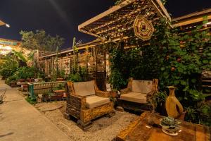 a garden with two chairs and a pergola at Hostal Valle Mistral in La Serena