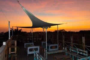 a tent on a deck with a sunset in the background at Hostal Valle Mistral in La Serena