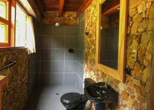 a bathroom with a shower and a toilet and a sink at Atarisi Lodge in Rurrenabaque