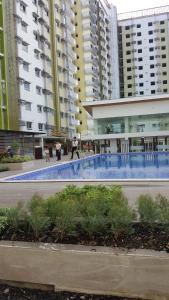 a swimming pool in a city with tall buildings at Mesaverte Residences AFS Suites in Cagayan de Oro