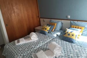 a bedroom with two beds with towels and pillows at Marisol 2F Waterfront in Armação de Pêra