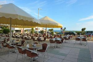 a group of tables and chairs with umbrellas at Marisol 2F Waterfront in Armação de Pêra