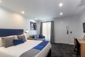 Un dormitorio con una cama tamaño king y un escritorio. en Town Square Motel, en Orange