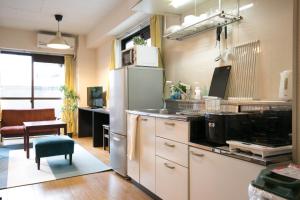 a kitchen with a refrigerator and a table with a chair at Nishi Nakasu apartment 301 in Fukuoka