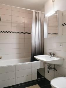 uma casa de banho branca com um lavatório e uma banheira em Apartment Fewo Irdning Pichlarn em Aigen im Ennstal