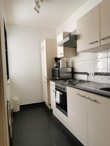 uma cozinha com armários brancos e um forno com placa de fogão em Apartment Fewo Irdning Pichlarn em Aigen im Ennstal