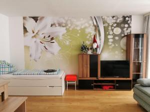 una sala de estar con un gran mural de flores en la pared en Apartment Fewo Irdning Pichlarn, en Aigen im Ennstal
