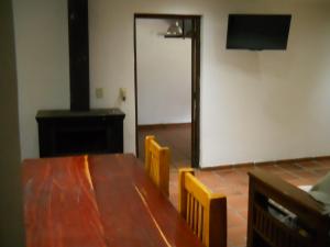 a room with a wooden table and chairs and a screen at Estilo Campo Casa de 3 ambientes cochera interna in Mar del Plata