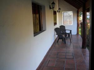 a porch with two chairs and a window on a house at Estilo Campo Casa de 3 ambientes cochera interna in Mar del Plata