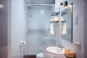 ein weißes Badezimmer mit Waschbecken und Dusche in der Unterkunft Hotel Puñuykuna - Cajamarca in Cajamarca