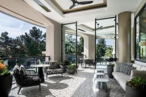 un patio al aire libre con sillas, mesas y ventanas en Four Seasons Hotel Westlake Village, en Westlake Village