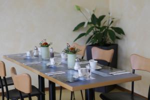 einen Tisch mit Stühlen und eine Pflanze an der Wand in der Unterkunft Stadthotel Kassel in Kassel