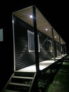 une maison la nuit avec les lumières allumées dans l'établissement Cielo Austral, à Puerto Natales