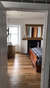 a bedroom with a bed and a fireplace and a window at Fasgadh Rooms in Tarbert