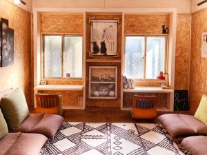 a living room with two couches and two windows at Shadow house in Tainan