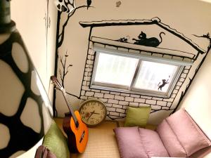 Zimmer mit Katzenregal, Uhr und Fenster in der Unterkunft Shadow house in Tainan