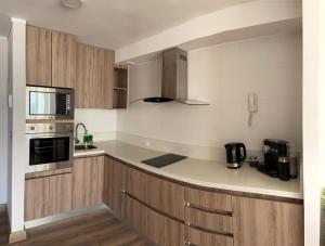 a kitchen with wooden cabinets and a counter top at Terrazas de Cochoa in Viña del Mar