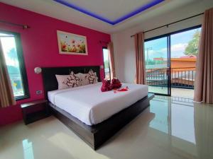 1 dormitorio con 1 cama grande y paredes rojas en Lanta Daisy Residence, en Ko Lanta