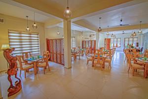 a restaurant with wooden tables and chairs and windows at Rivora Residence in Kandy