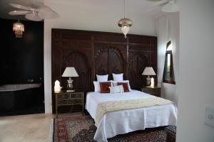 a bedroom with a large bed and a bath tub at Jodha Bai Retreat in Terranora