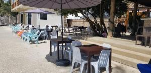 a group of tables and chairs with an umbrella at Tropical Fun Ta Sea Rentals in Siquijor